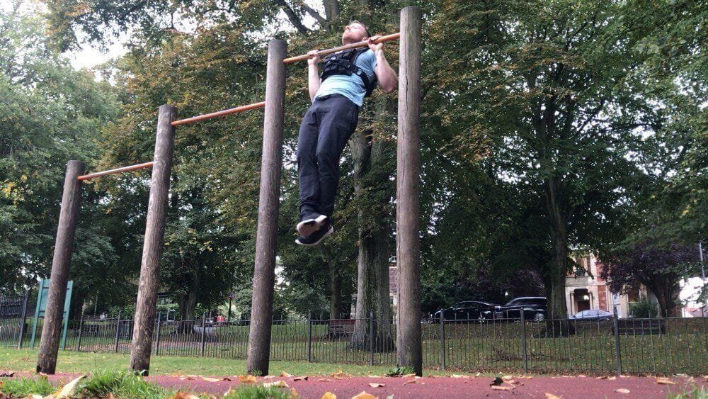 A weighted pull-up wearing a Gravity Fitness weighted vest