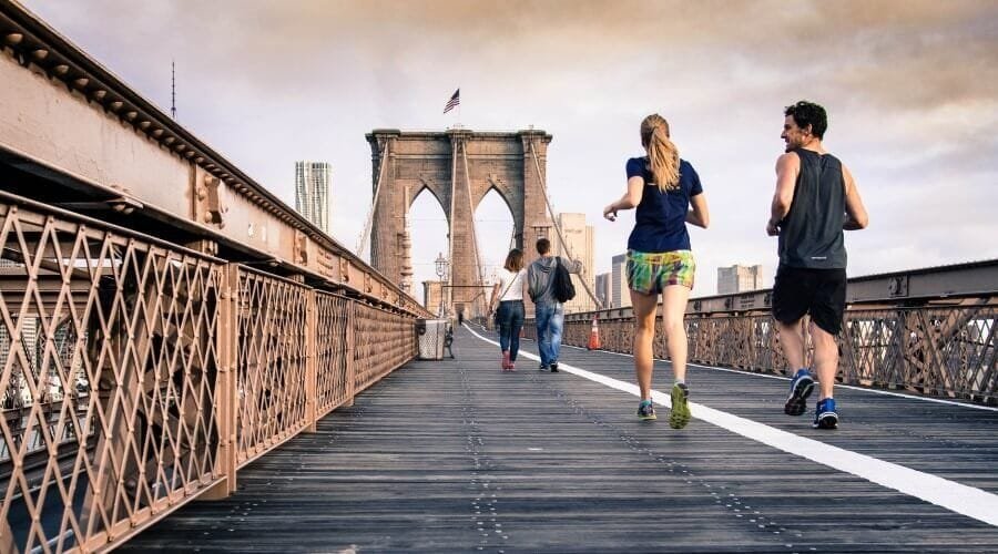 Group of people running over bridge