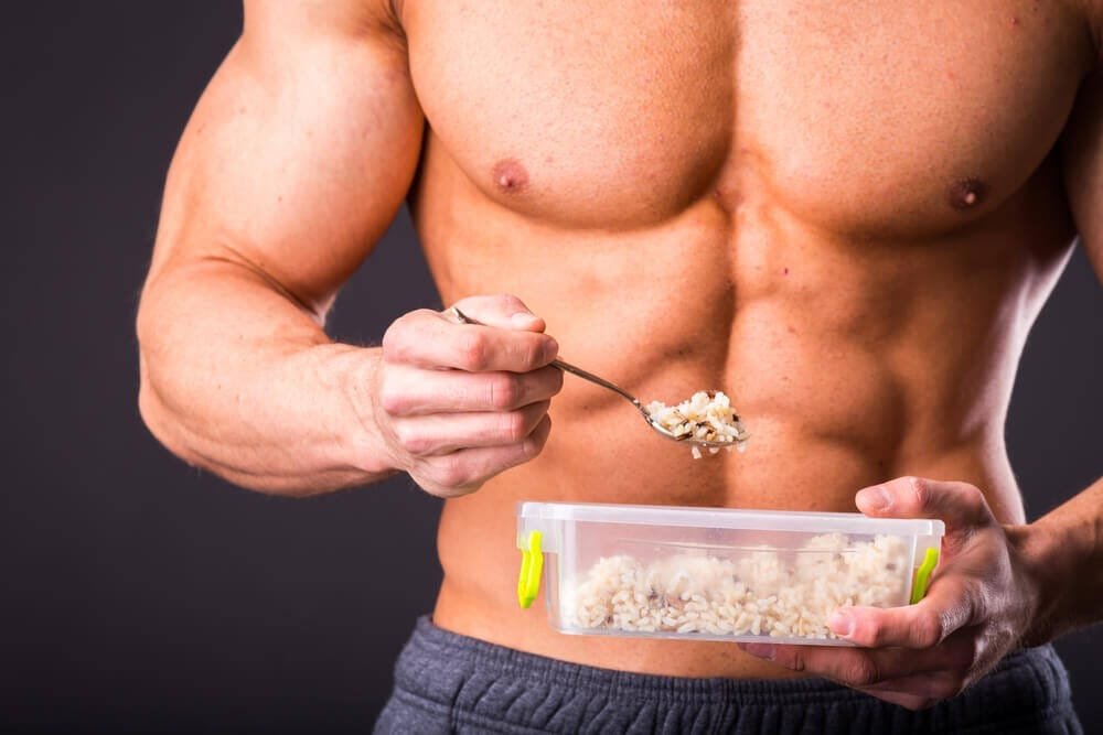 Muscular man eating healthy food