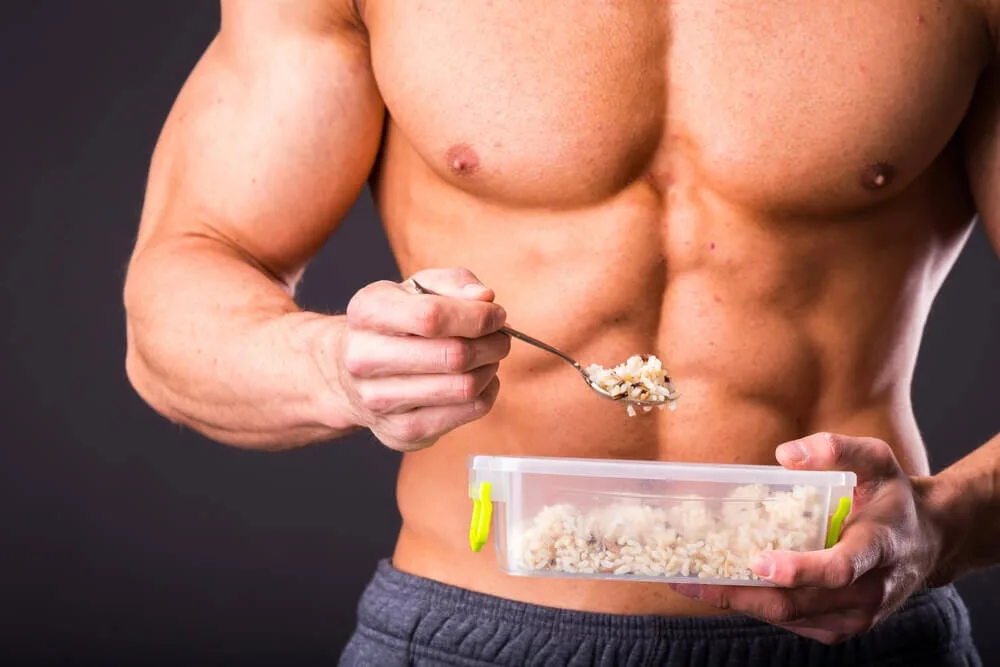 Muscular man eating healthy food