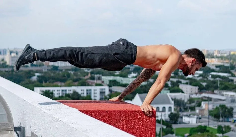 Osvaldo Lugones performing planche skill on rooftop edge