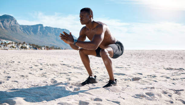 Man squatting on a beach