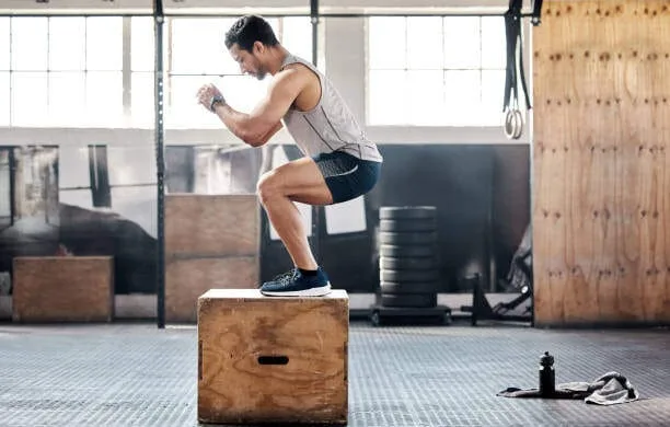 Man squatting on a box